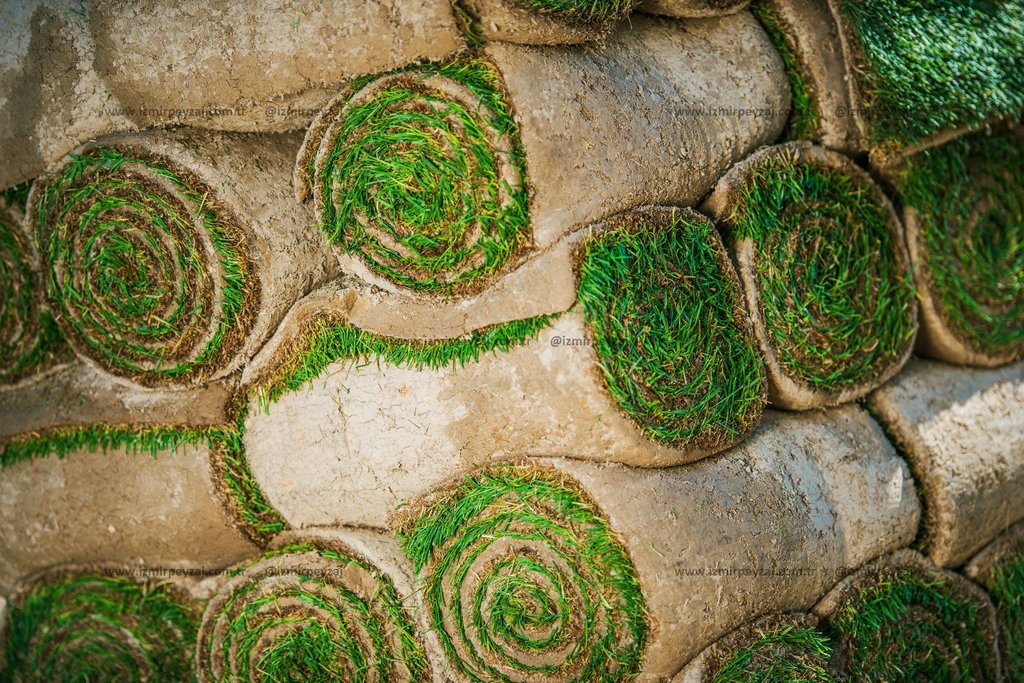 Rulo çim balyaları istiflenmiş şekilde duruyor. Bahçe düzenlemesi ve peyzaj uygulamaları için ideal bir görsel.