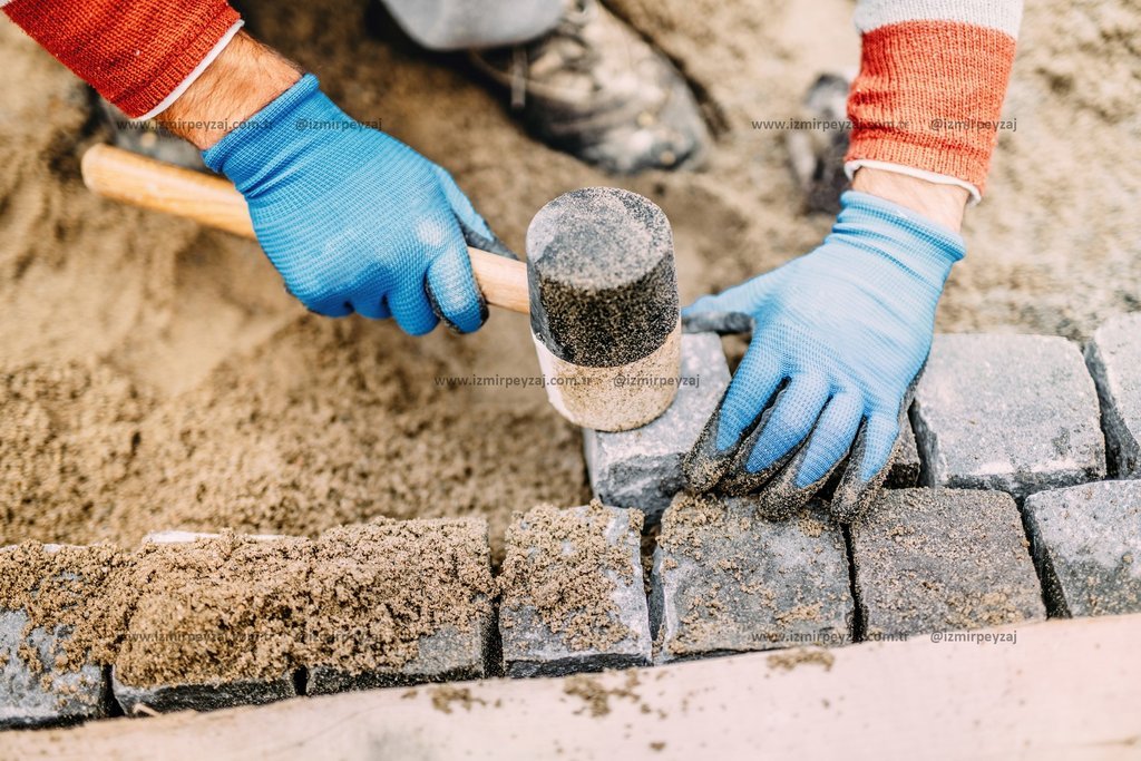 Bahçe yolları için doğal taş döşeme çalışması yapan peyzaj ekibi.